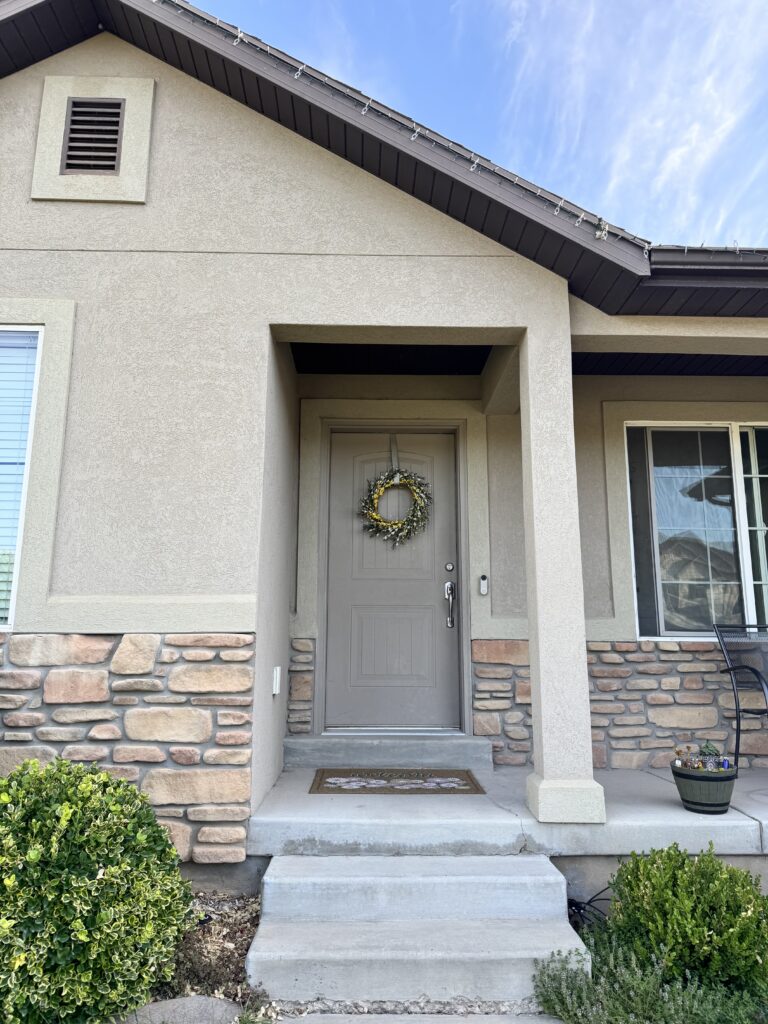 Front porch and wreathed door of a family home, the threshold between the workday and being present at home.